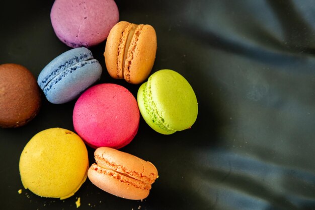 Kleurrijke macarons op zwarte achtergrond close-up bekijken