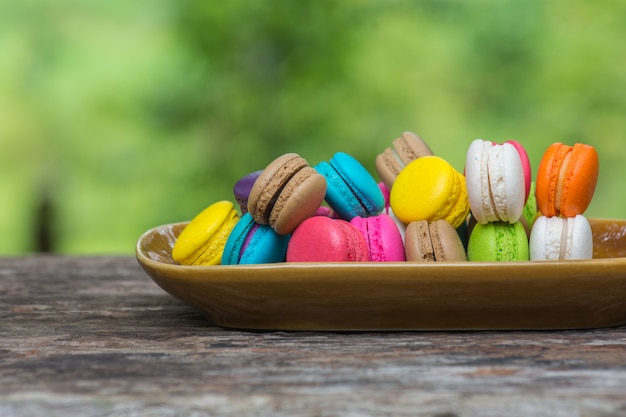 Kleurrijke Makarons in schotel op houten lijst