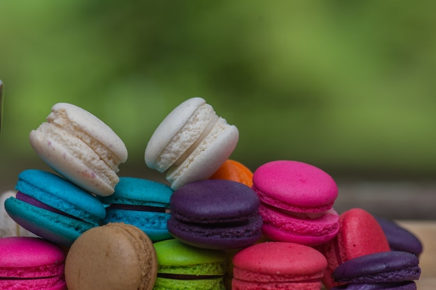 Kleurrijke Makarons in schotel op houten lijst