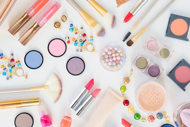 Kleurrijke make-up en borstels producten plat lag scène op witte achtergrond