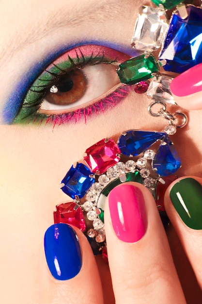 Kleurrijke make-up en manicure op korte nagels