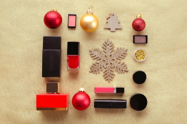 Kleurrijke make-upcosmetica met kerstversiering op gouden textielachtergrond