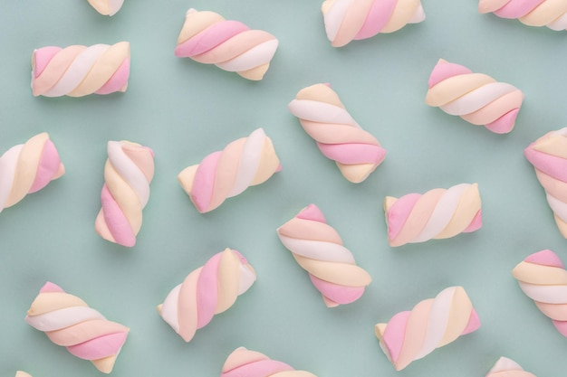 Kleurrijke marshmallow aangelegd op pastel achtergrond. Creatief structuurpatroon.