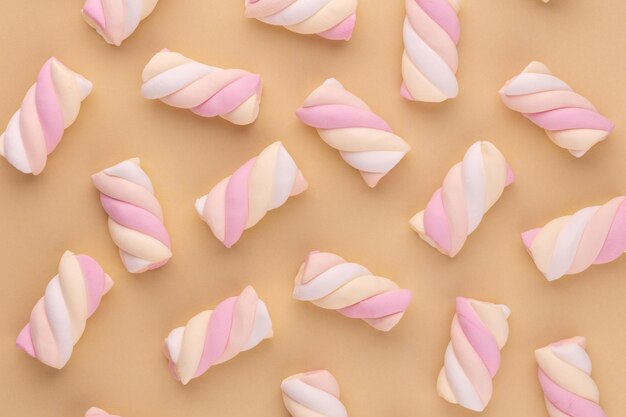 Kleurrijke marshmallow aangelegd op pastel achtergrond. Creatief structuurpatroon.