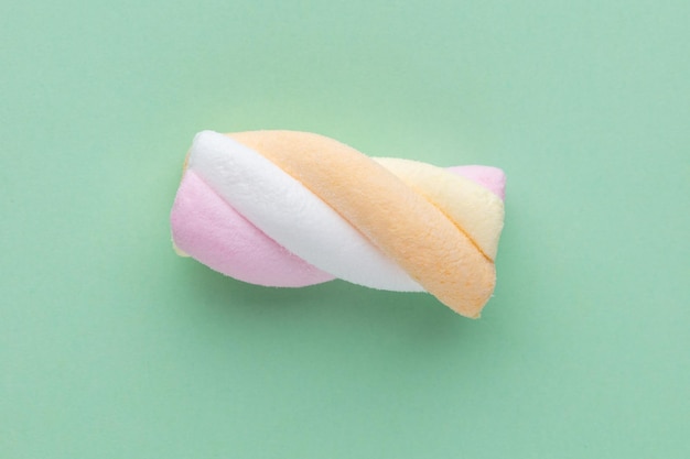 Kleurrijke marshmallows op pastel achtergrond.