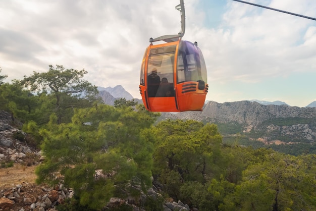 Kleurrijke oranje kabelbaan die over bergbossen gaat