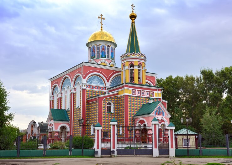 Kleurrijke orthodoxe kerk onder een blauwe bewolkte hemel. Abakan, Khakassia, Siberië, Rusland