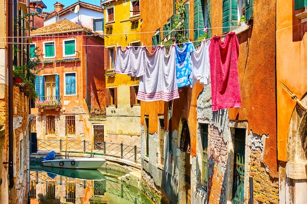 Kleurrijke oude huizen door kanaal in Venetië met het luchten van linnen op een zonnige dag, Italië