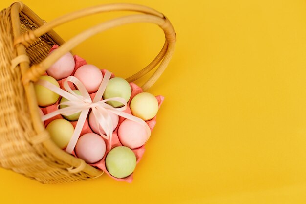 Kleurrijke paaseieren gele achtergrond in de mand Plaats voor de inscriptie Spring Easter