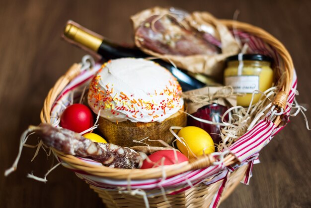 Kleurrijke paaseieren in een mand met cake