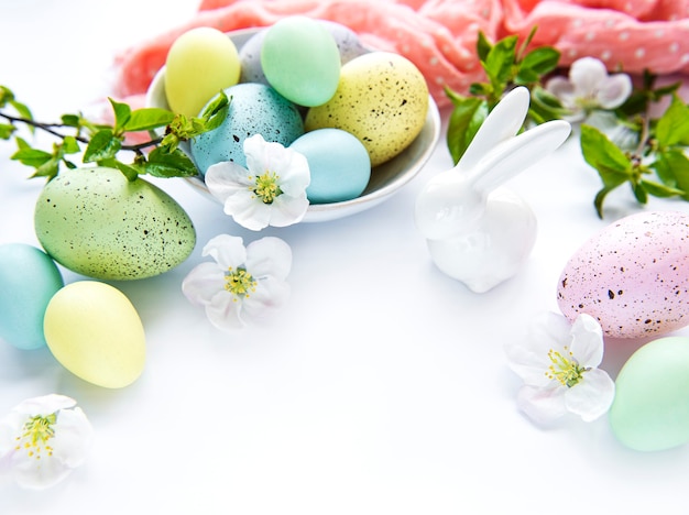 Kleurrijke paaseieren met bloesem Lentebloemen geïsoleerd op witte tafel.