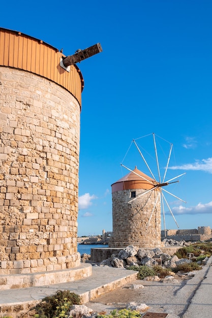 Kleurrijke panoramische uitzicht op windmolens met jachten in de haven van Mandraki bij zonsondergang Rhodos Griekenland