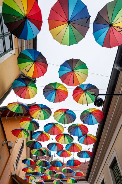 Kleurrijke paraplu'sachtergrond met blauwe lucht in de stadsstraatdecoratie