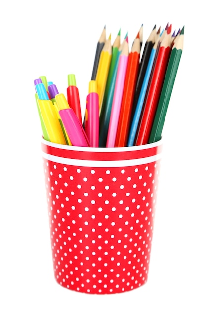 Kleurrijke pennen en potloden in rode polkadot plastic beker geïsoleerd op een witte achtergrond
