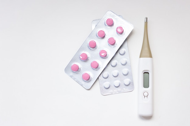 Kleurrijke pillen, capsules, tabletten en thermometer.