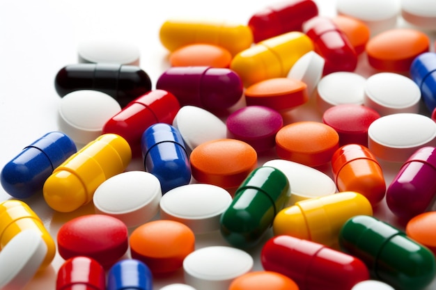 Kleurrijke pillen en capsules met vitamines en medicijnen op een witte achtergrond