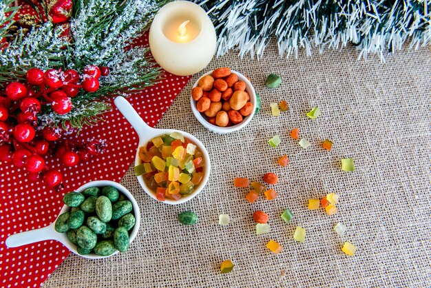 Kleurrijke pinda's en kleurrijk gekonfijt fruit op een tafelblad van Kerstmis.