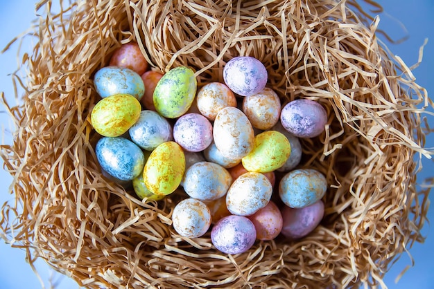 Kleurrijke plastic paaseieren in handgemaakte nest close-up. Feestelijke tafeldecoratie voor traditionele vieringen.