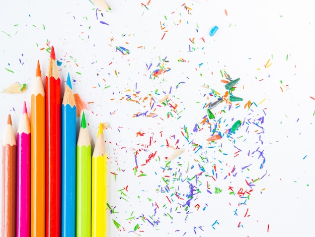 Kleurrijke potloden met kleurrijke potloodspaanders op witte achtergrond.