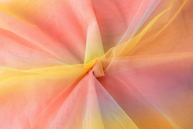 Kleurrijke regenboog organza stof textuur achtergrond. Geel roze blauwe achtergrond