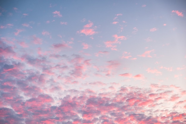 Kleurrijke roze wolken op blauwe hemel in de schemering