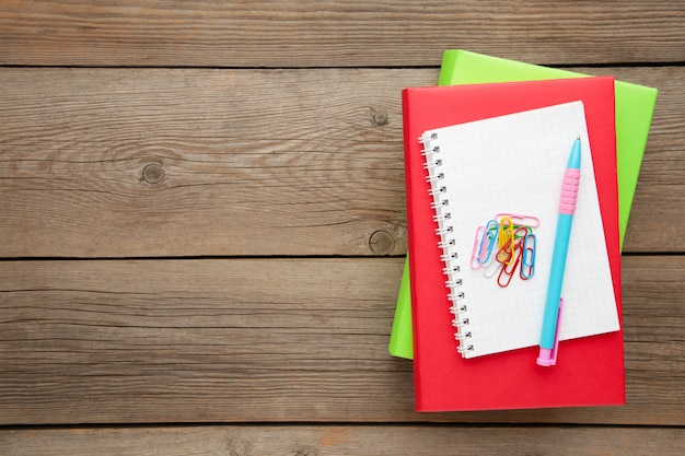 Kleurrijke schoolboeken met pen op grijze houten achtergrond