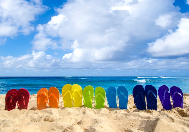 Kleurrijke slippers op het zandstrand