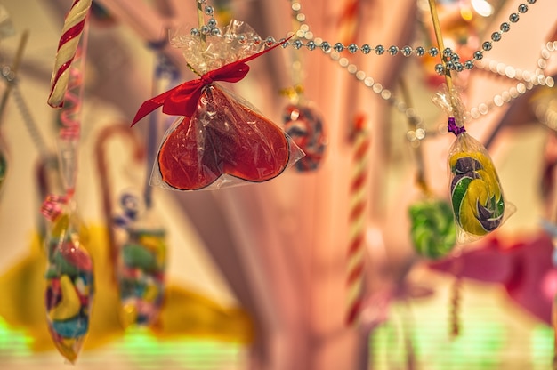 Foto kleurrijke snoepjes en snoepjes worden opgehangen als decoraties close-up
