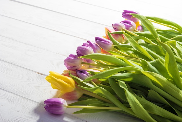 Kleurrijke tulpen op een houten tafel. Bovenaanzicht met kopie ruimte