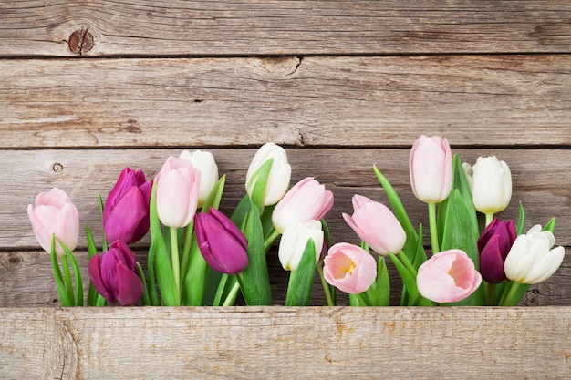 Kleurrijke tulpen over houten achtergrond