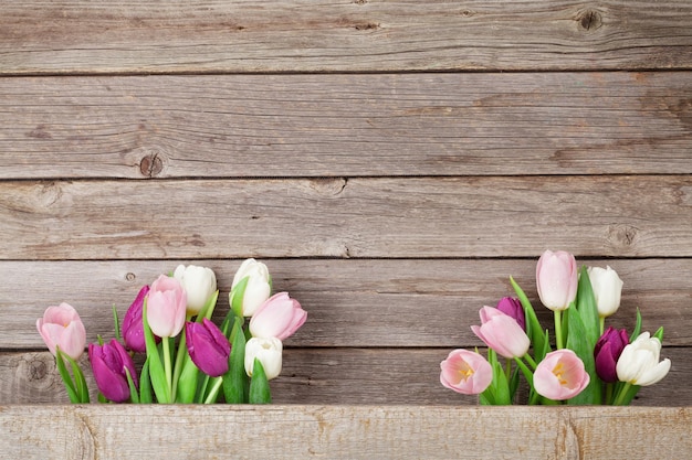 Kleurrijke tulpen over houten achtergrond