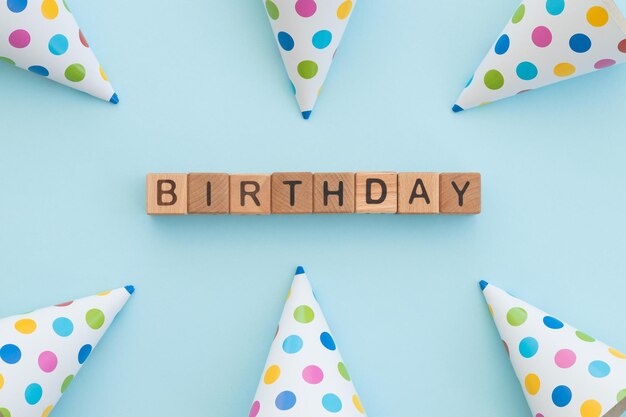 Kleurrijke verjaardag caps en word happy birthday geschreven houten kubussen geïsoleerd op blue