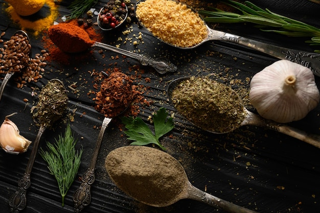 Kleurrijke verschillende kruiden en specerijen voor het koken op donkere houten rustieke achtergrond