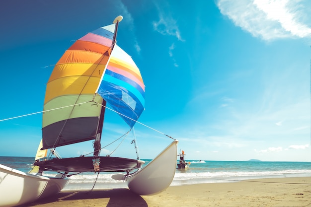 Kleurrijke zeilboot op tropisch strand in de zomer.