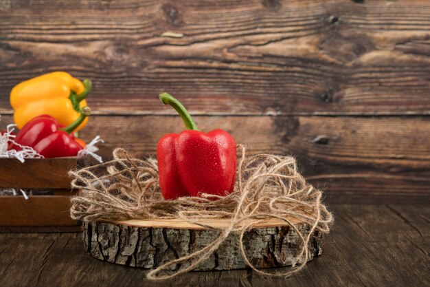 Kleurrijke zoete paprika's die op houten stuk worden geplaatst