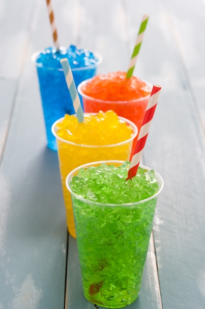 Kleurrijke zomer slushies op blauwe houten tafel