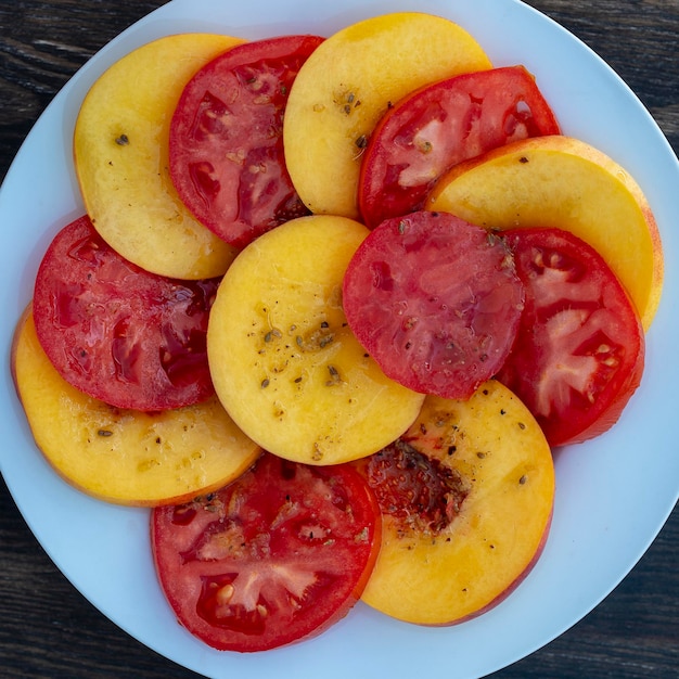 Kleurrijke zomersalade met tomaat en nectarines close-up bovenaanzicht