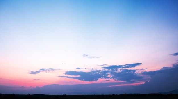 Kleurrijke zonsondergang en zonsopgang met wolken. Blauwe en oranje kleur van de natuur. Veel witte wolken in de blauwe hemel. Het weer is duidelijk vandaag. zonsondergang in de wolken. De hemel is schemering.