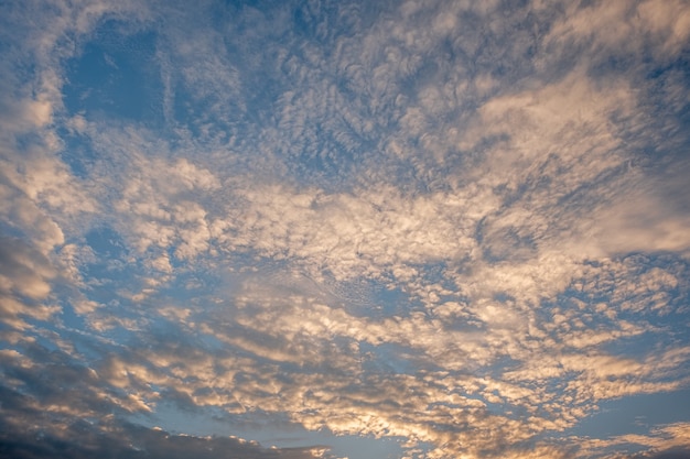 Kleurrijke zonsondergang en zonsopgang met wolken. Blauwe en oranje kleur van de natuur. Veel witte wolken in de blauwe hemel. Het weer is duidelijk vandaag. zonsondergang in de wolken. De hemel is schemering.