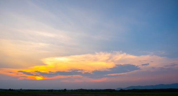 Kleurrijke zonsondergang en zonsopgang met wolken. Blauwe en oranje kleur van de natuur. Veel witte wolken in de blauwe hemel. Het weer is duidelijk vandaag. zonsondergang in de wolken. De hemel is schemering.