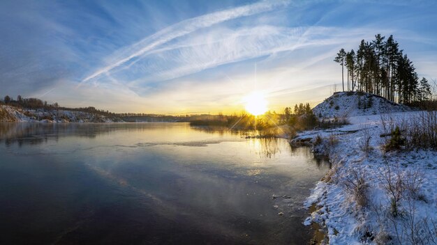 Kleurrijke zonsondergang in de winter aan de oever van een ijskoud meer