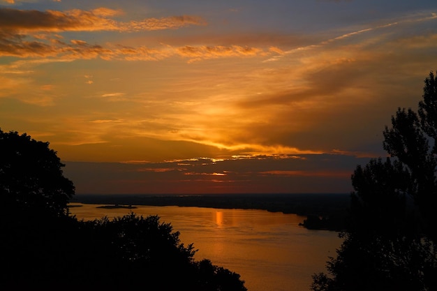 Kleurrijke zonsonderganghemel boven de rivier in het gouden uur