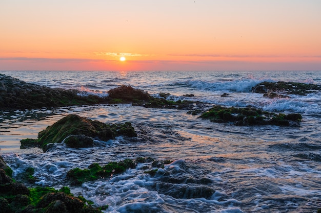 Kleurrijke zonsopgang op een rotsachtige kust