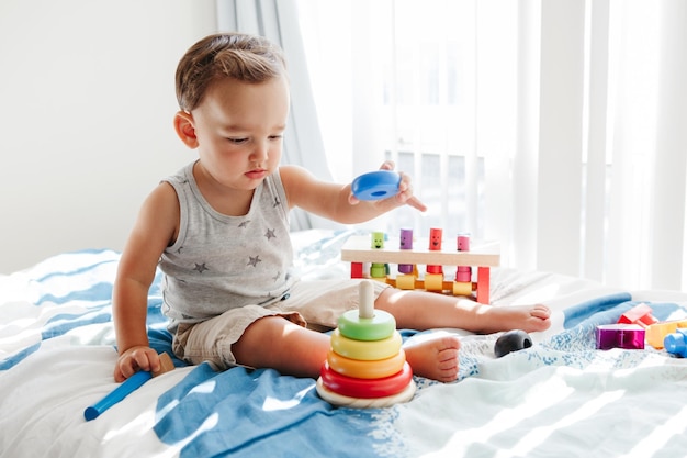 Kleuter speelt met het leren van speelgoed piramide stapelen van blokken thuis vroege leeftijd Montessori onderwijs