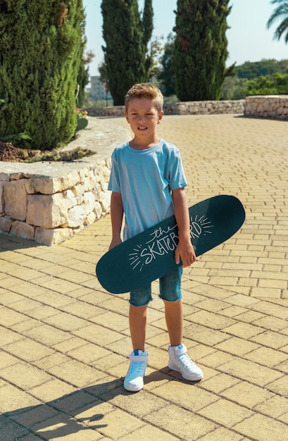 Kleuterjongen houdt een skateboard in handen in het park