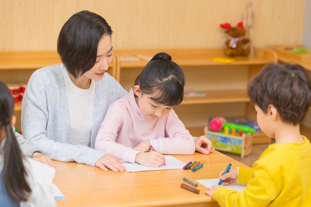 Kleuterjuf speelt met kinderen