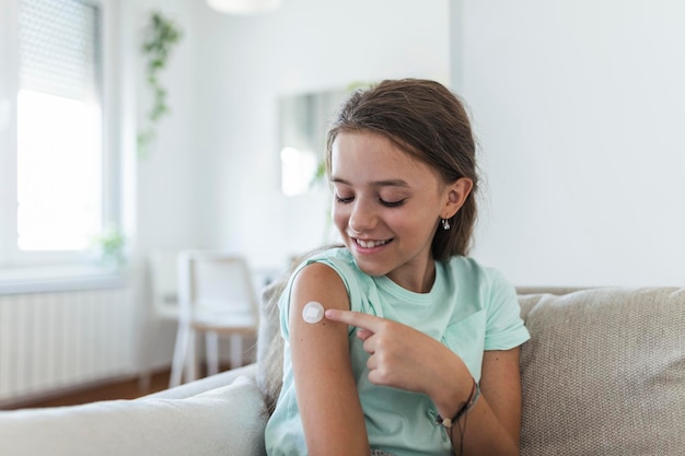 Kleverige verband op de arm na injectie vaccin of medicijnKleverige verband plaster Medische apparatuur Zachte focus Kleverig verband op een vrouwelijke brachium na COVID-19 vaccinatie