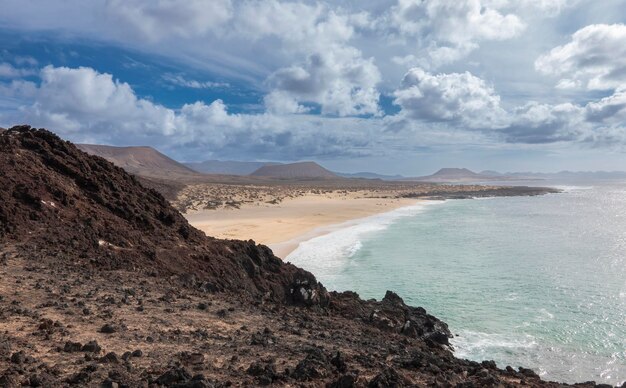 Kliffen en ongerepte stranden op het eiland La Graciosa, met de Risco de Famara op de achtergrond