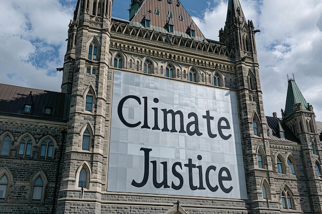 Klimaatrechtvaardigheid tekst op een spandoek buiten het parlement