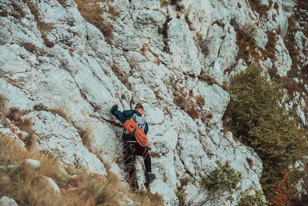 Klimmer die een moeilijke klimroute op de rotsberg overwint